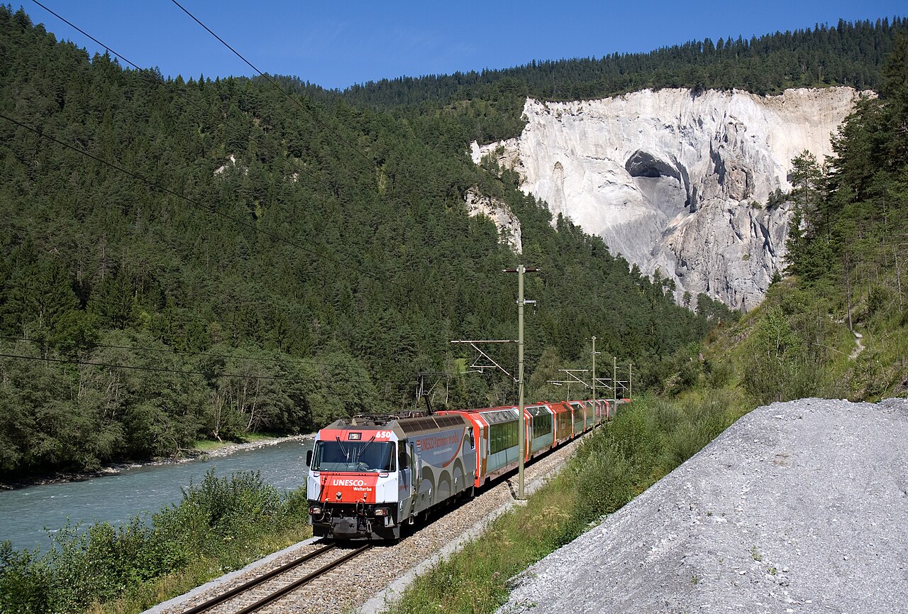Glacier Express panoramic train beside the river and pale cliffs of the Rhine Gorge
